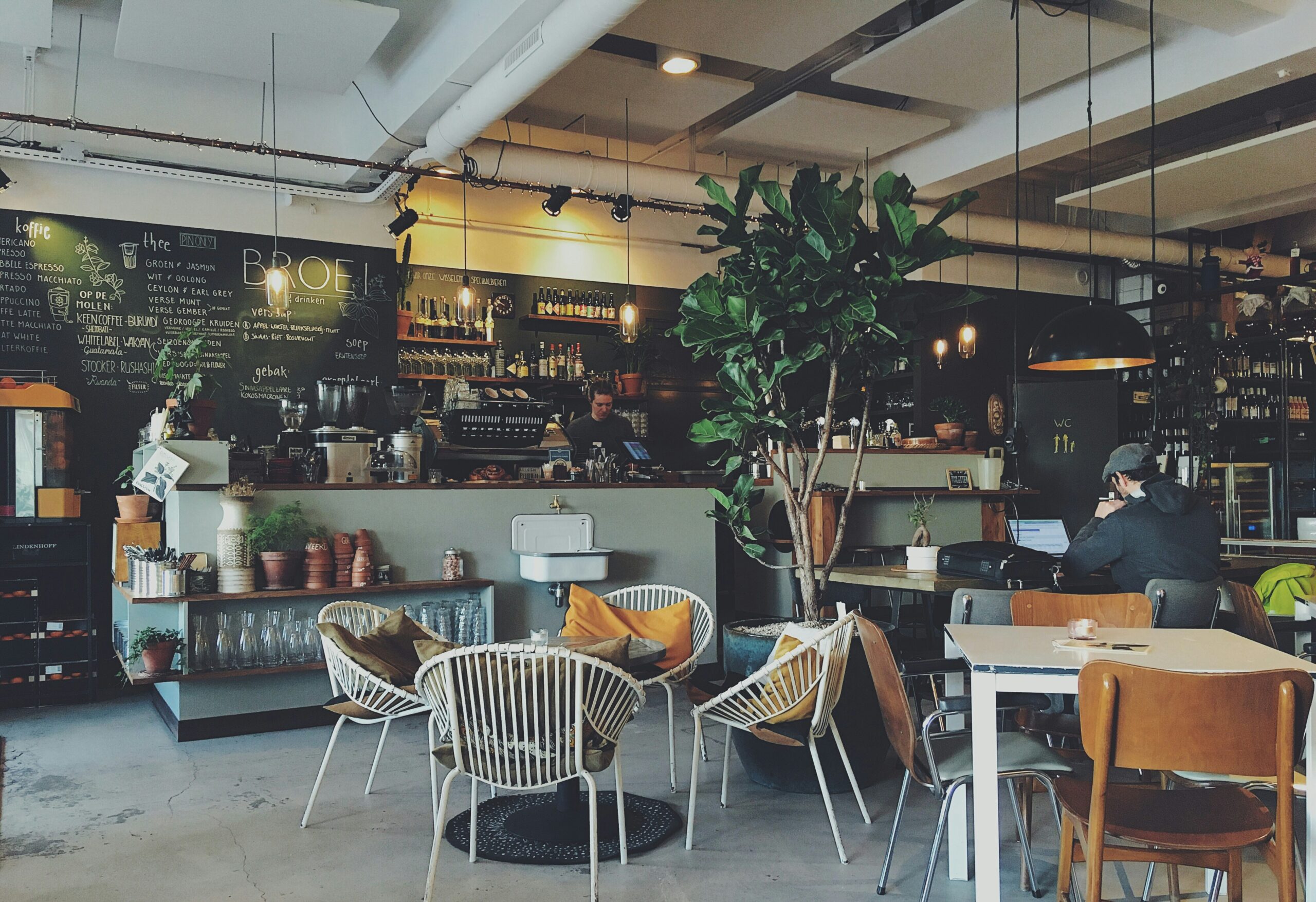 Modern cafe interior with customers and a barista, representing hospitality insurance for Australian cafes and restaurants