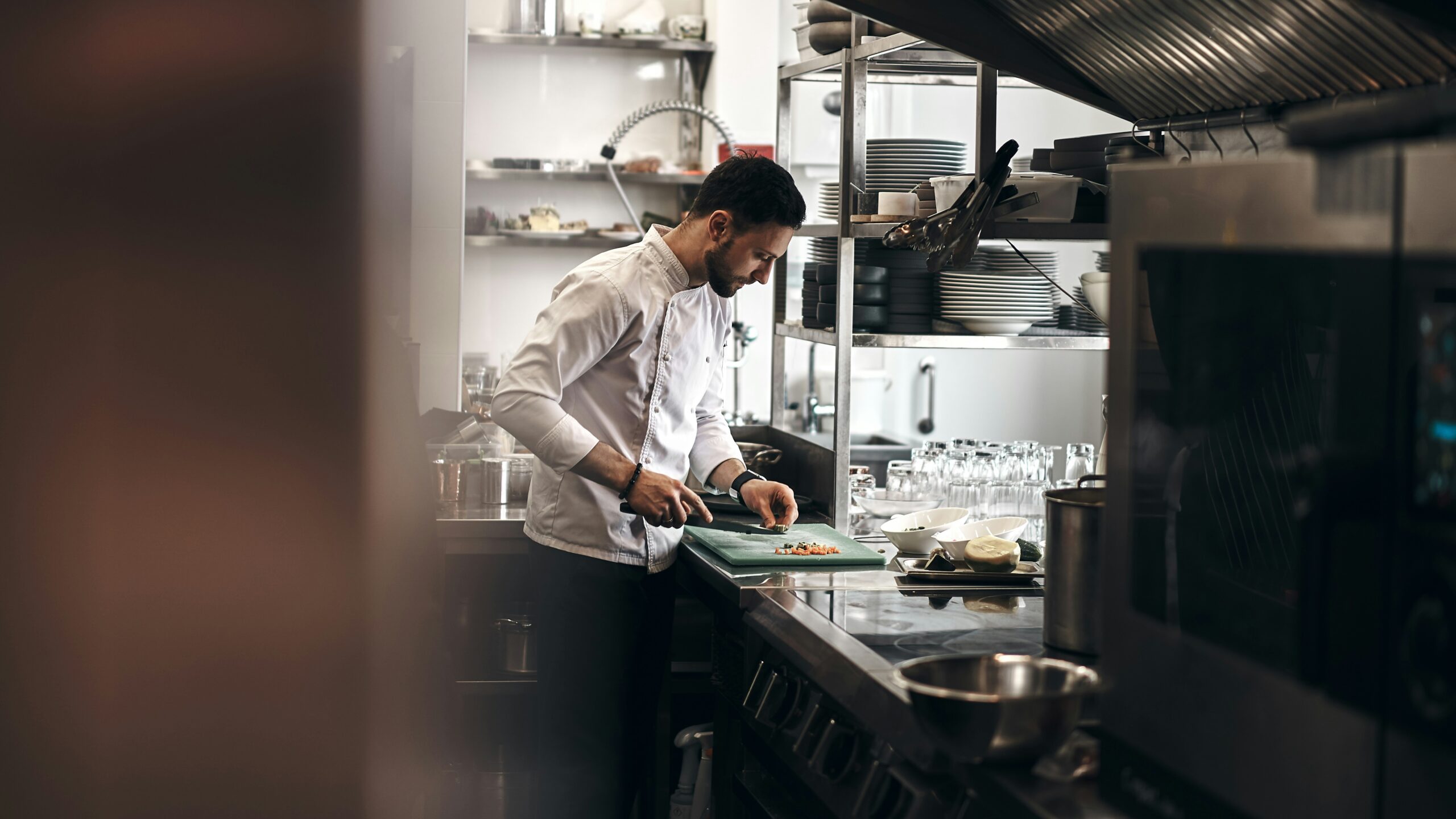 Chef preparing food in a commercial kitchen, representing hospitality insurance risks and equipment